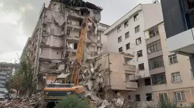 Yıkımı yapılan binadan kopan molozlar arkadaki apartmana zarar verdi