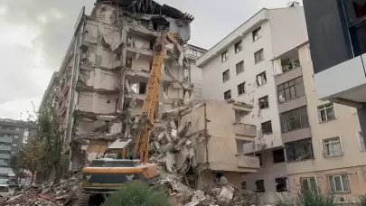 Yıkımı yapılan binadan kopan molozlar arkadaki apartmana zarar verdi