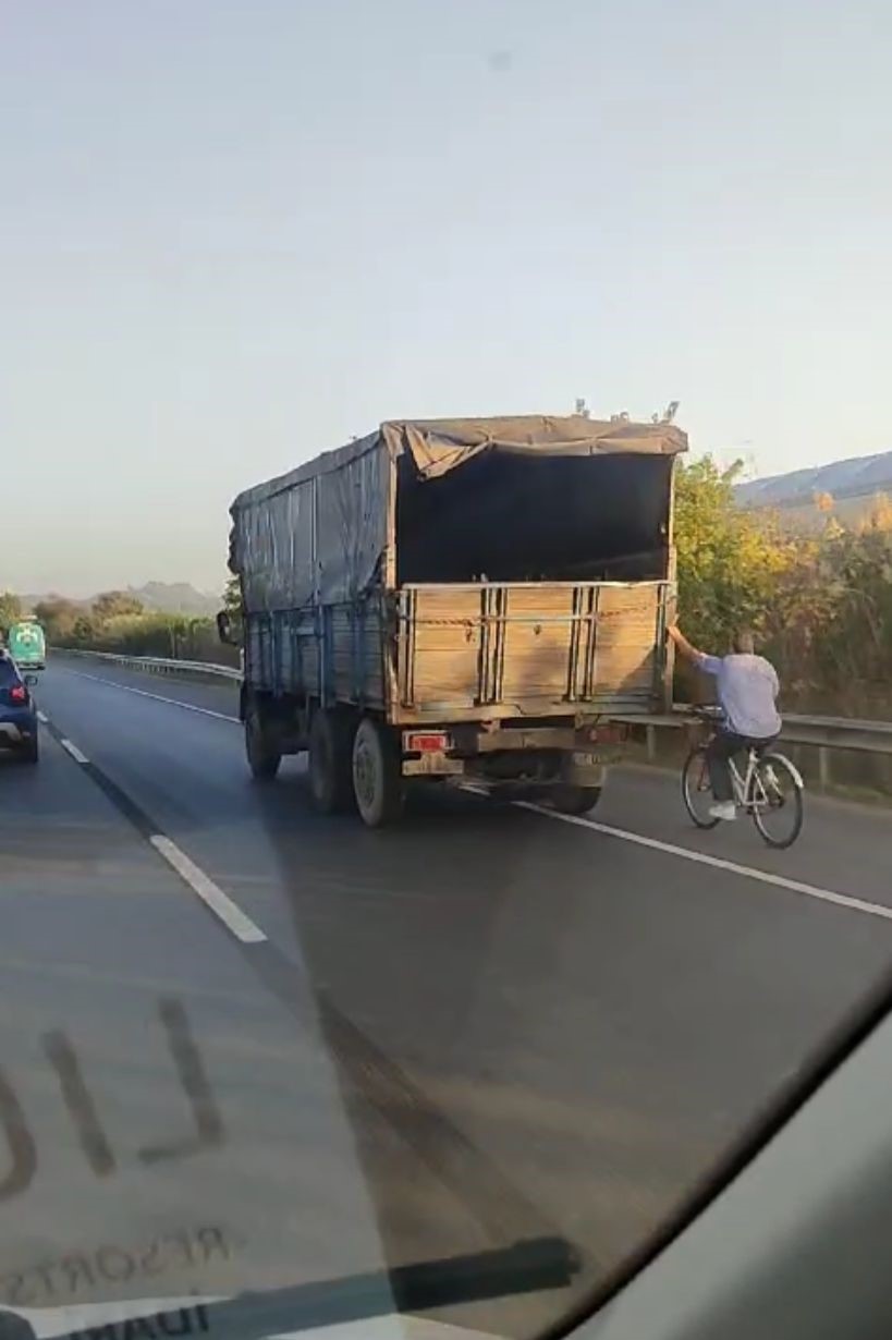 Hızla giden kamyonun arkasına tutunan bisikletli yürekleri ağza getirdi